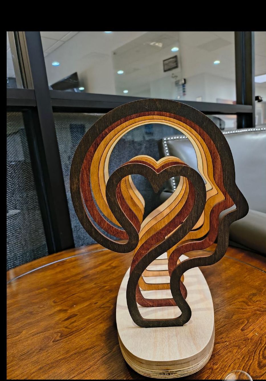 God Loves Diversity sculpture — layered maple plywood human profile with heart motif